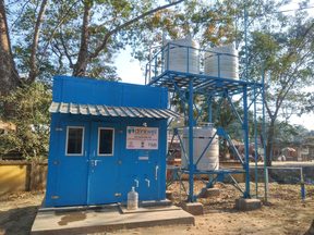 A solar-powered community water kiosk with raised storage tanks in Assam.